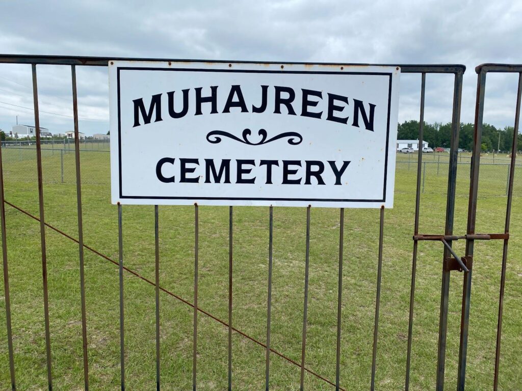 the sign which is on the iron fence leading into the cemetery